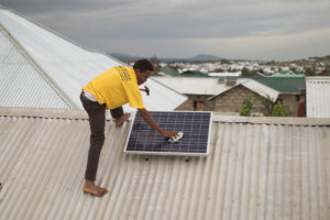 Die Installation eines Solarmoduls auf einem Haus in Tansania.